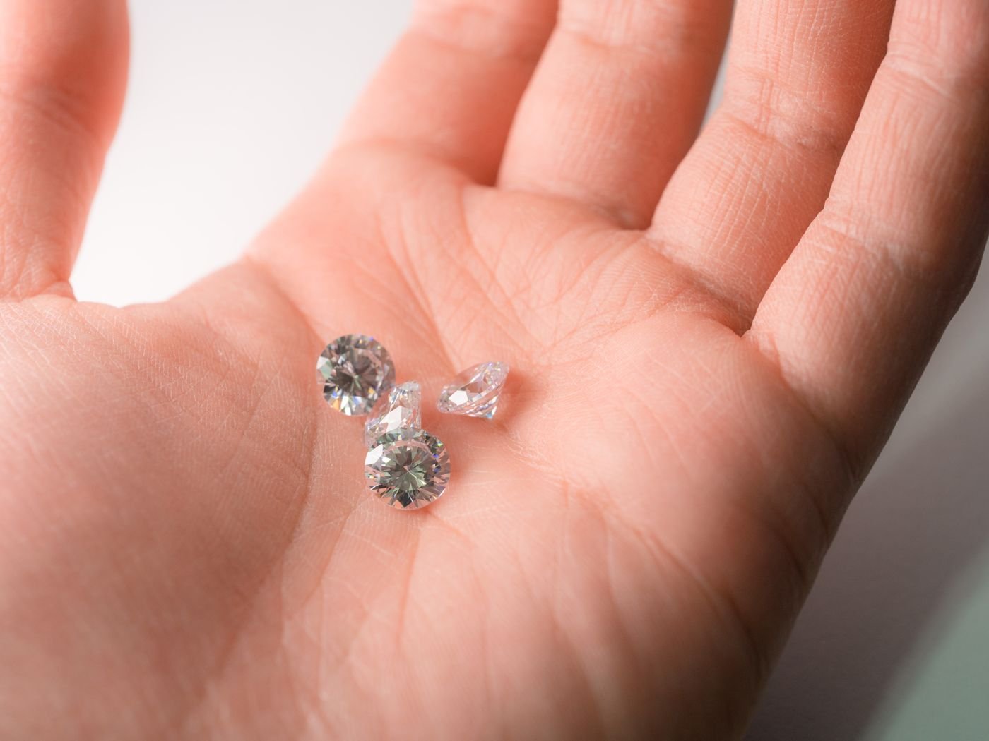 Loose diamonds resting in a palm, glistening